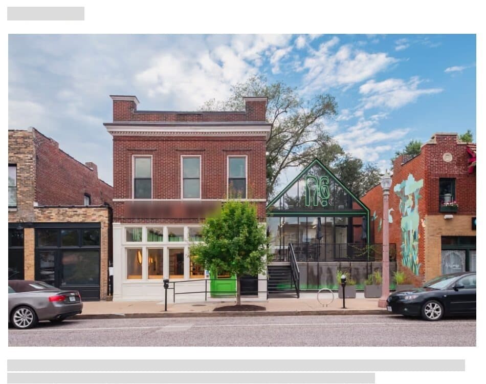 A project page: a wide photograph of a brick street front with a glass extension, with the title and text greyed out.